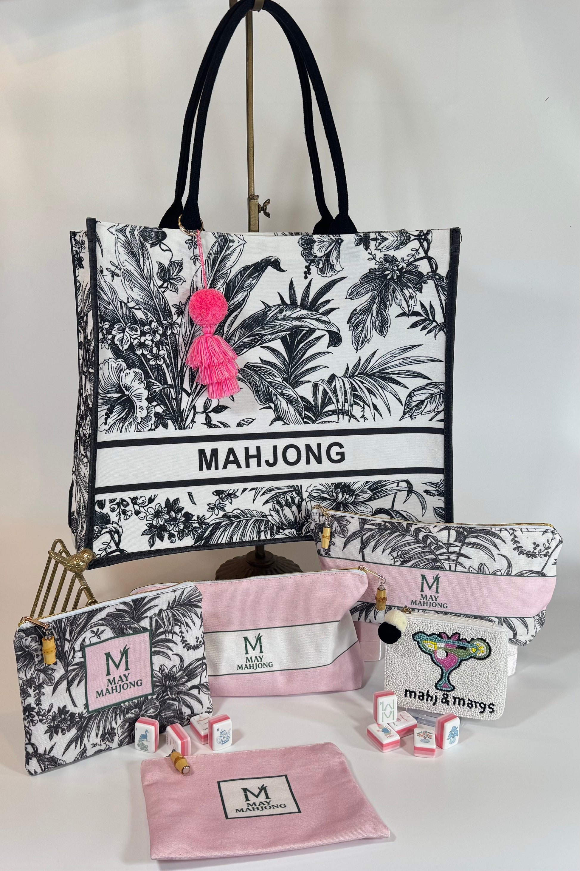 Set of 'MAHJONG' branded bags and pouches with floral design on a white background