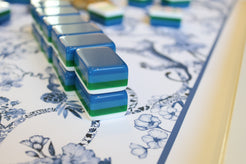 Blue and green tiles on a floral-patterned tablecloth
