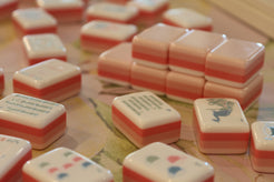 Close-up of pink and white game pieces on a board game surface