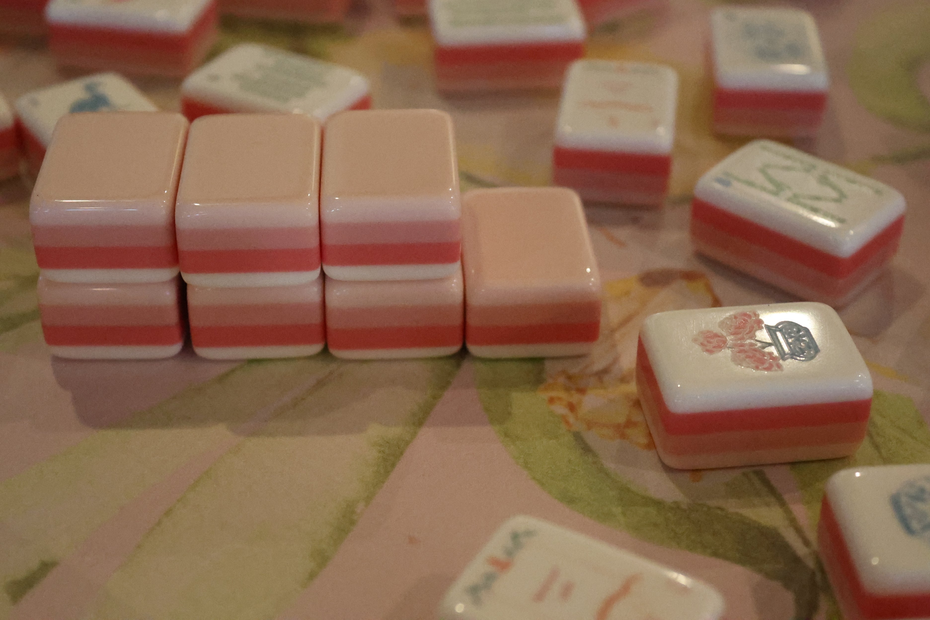 Stack of pink and white game pieces on a patterned surface